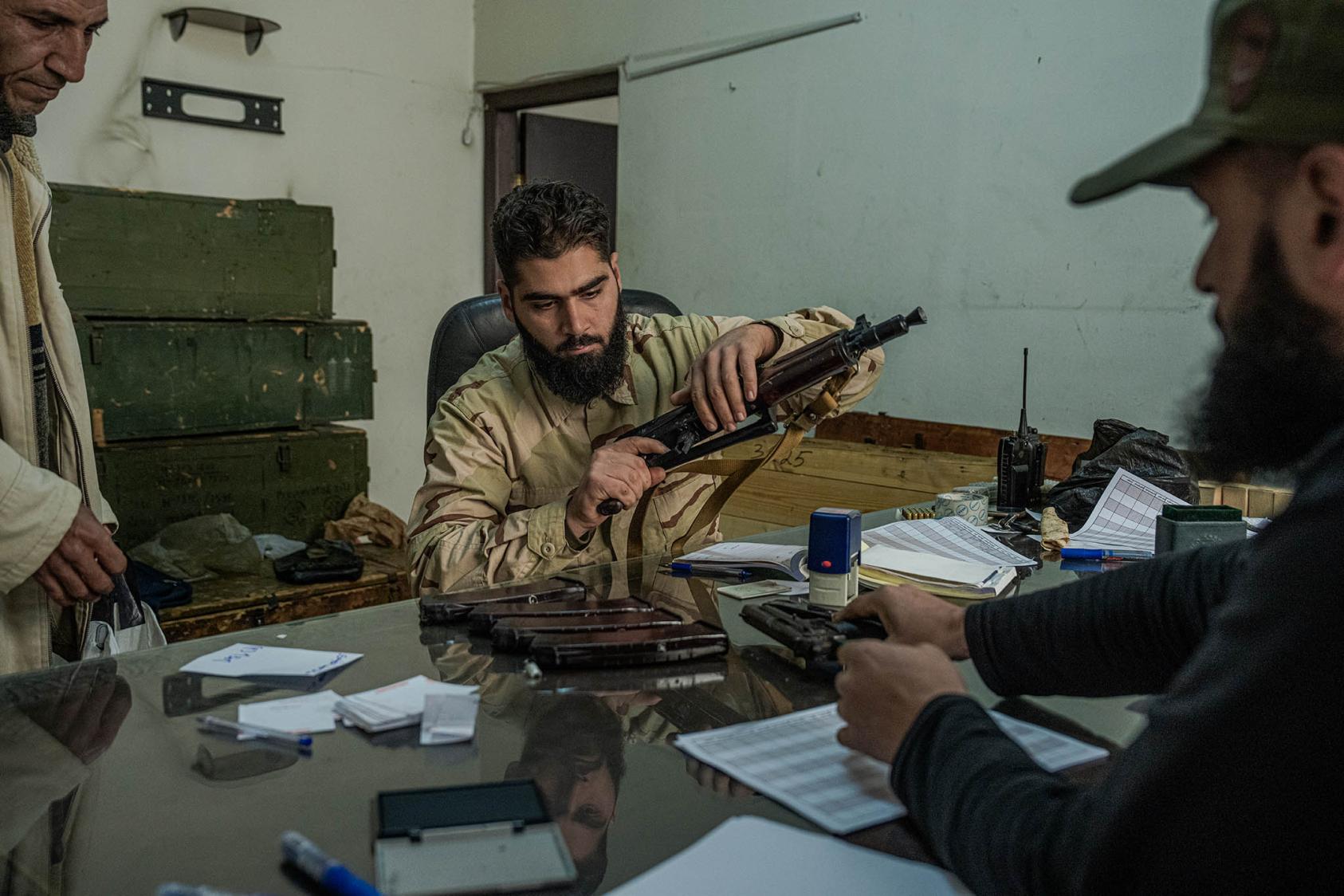 A man hands in his firearm to a reconciliation center in Damascus, Syria, Dec. 23, 2024. (Daniel Berehulak/The New York Times)